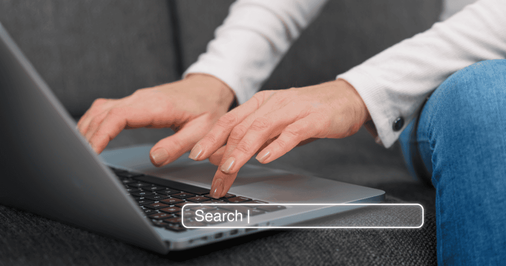 A close-up shot shows hands typing a query into a search bar on a laptop screen; checking popular interest will confirm which concepts are worth pursuing.