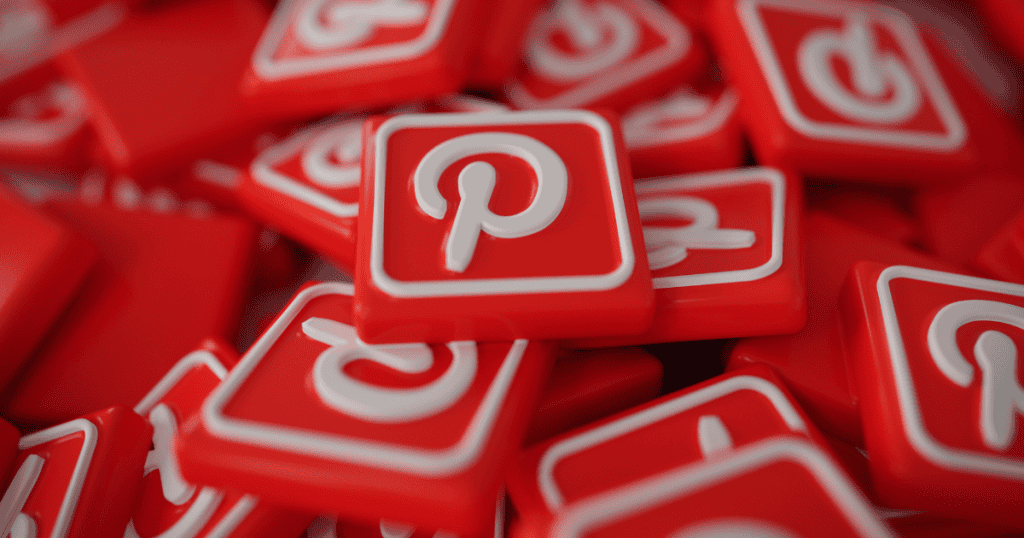 A high-angle pile of glossy red 3D Pinterest logo tiles, representing the complex layers and accumulated responsibilities of earning on the platform.