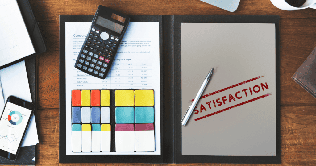 A folder on a wooden desk containing a calculator and a document stamped "SATISFACTION," highlighting the importance of verifiable standards and reliability.