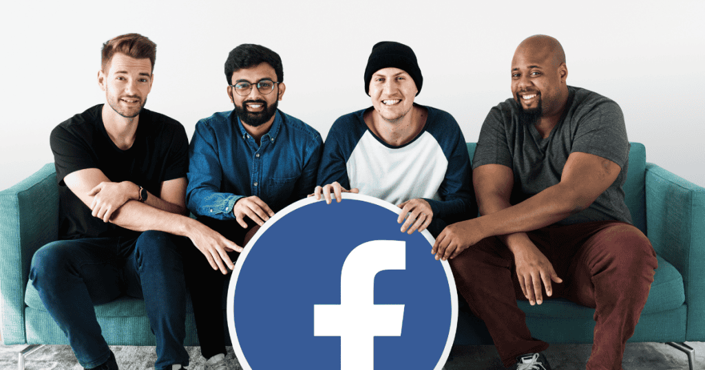Four men sit together on a turquoise sofa while smiling, collectively holding a large circular sign that displays a prominent social media logo.